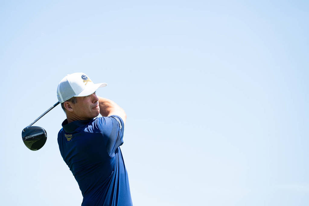 a golf player mid swing