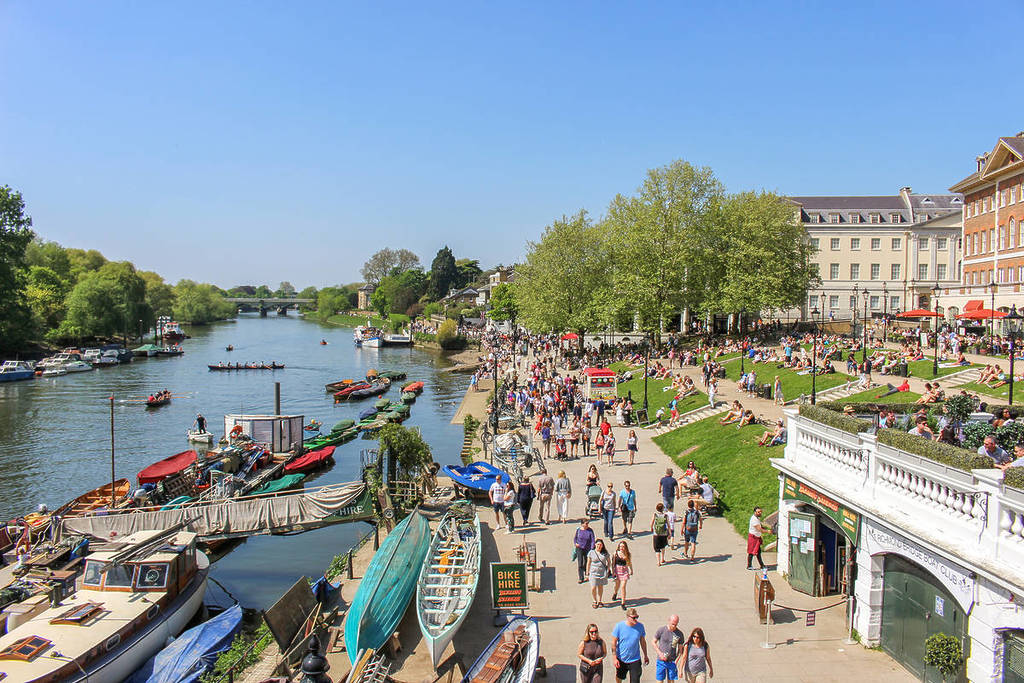 Leute, die an einem sonnigen Tag in Richmond upon Thames am Fluss entlang spazieren