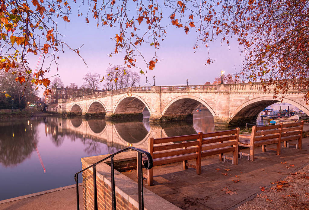 a bridge in richmond upon thames with a pink sky casting a soft pink light over the water