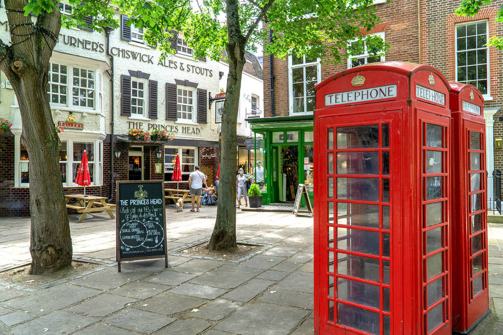 Ein Stadtplatz in Richmond upon Thames mit sichtbaren Pubs und einer roten Telefonzelle