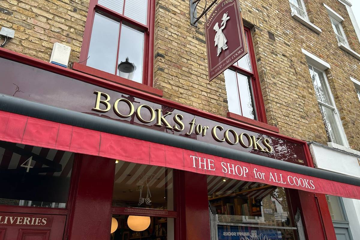 Exterior of shop with burgundy sign reading "books for cooks" and another sign reading "the shop for all cooks"