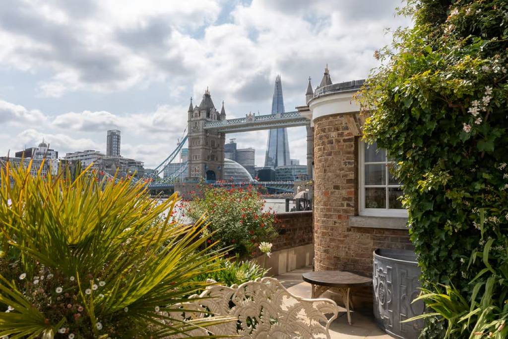 Die Gartenterrasse einer Immobilie an der Themse mit Blick auf die Tower Bridge und den Shard
