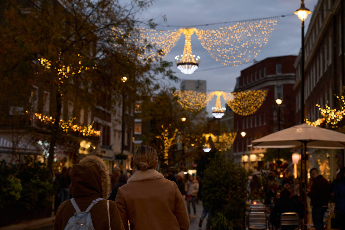 people walking around under the belgravia christmas lights