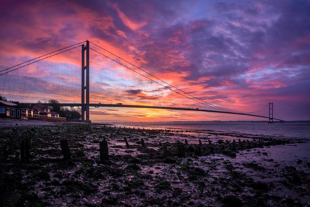 Alba dell'Humber Bridge con cielo rosso e arancione.