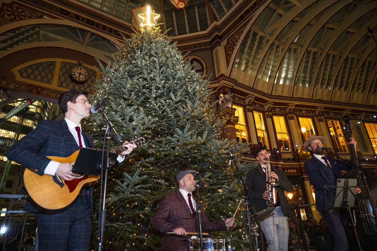 a band performing in front of a christmas tree in leadenhall market