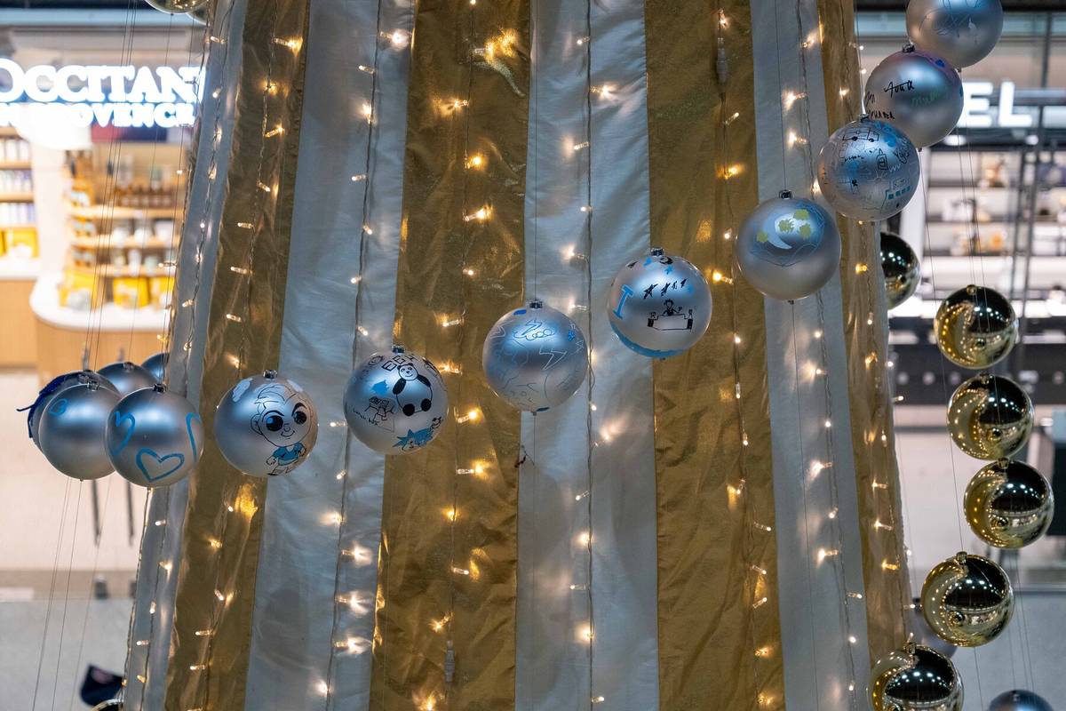 a close-up on hand-decorataed baubles strung up around a christmas tree