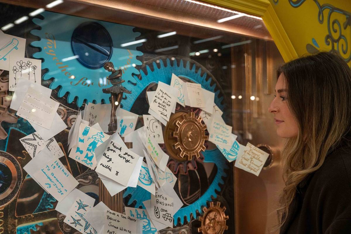 a window showing handwritten wishes tracing a journey through the gears of a machine