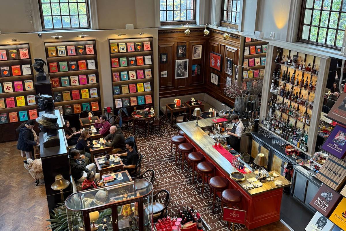 Image from above showing the bookshelves with some tables in front of them with a bar to the right