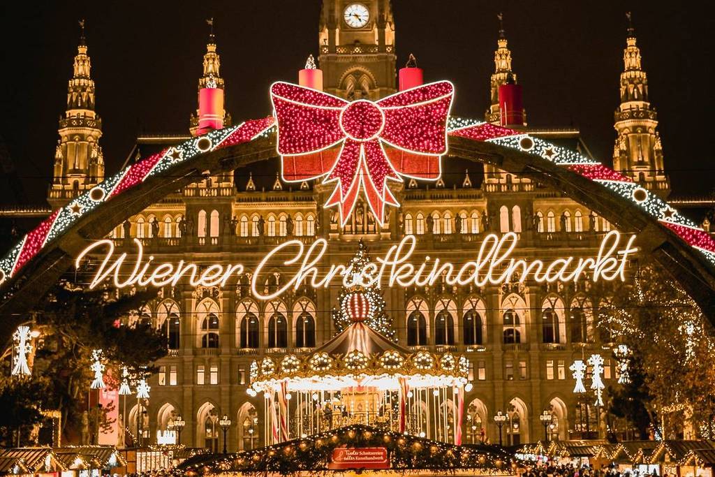 Christmas market at night wit a lit up sign that says 