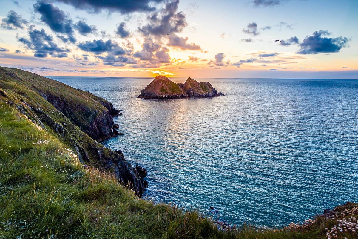 Some rocks in the ocean in Cornwall at sunset
