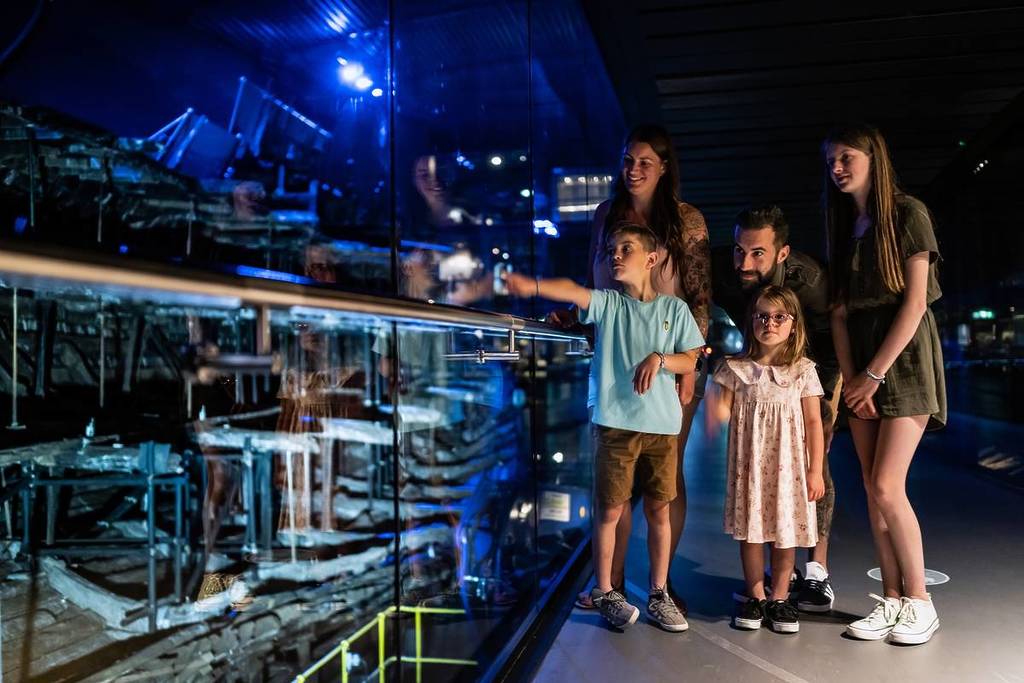 Family with kids pointing at something at the Mary Rose Museum