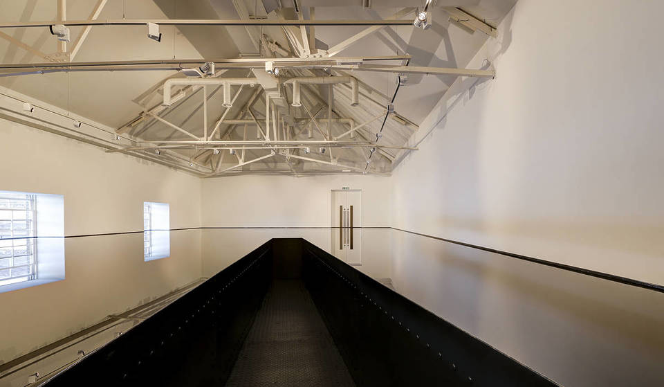 El último piso de esta galería de arte londinense se ha llenado de aceite de motor, creando una instalación cautivadora y alucinante en la que no sabes qué camino es el de arriba.