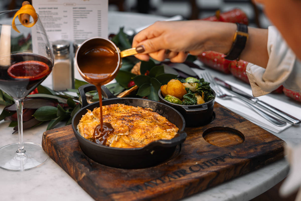 someone pouring gravy over the top of a turkey and chestnut pie