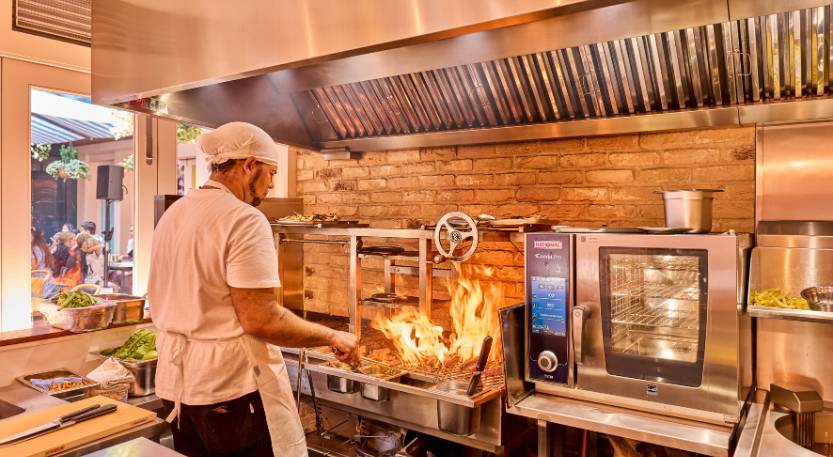 a chef working at a fryer in a restaurant