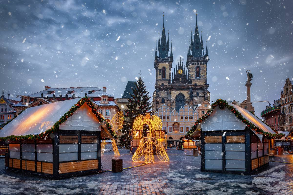 Beautiful winter view of the old town square of Prague, Czech Republic, with a christmas market and the famous Tyn Church with snow