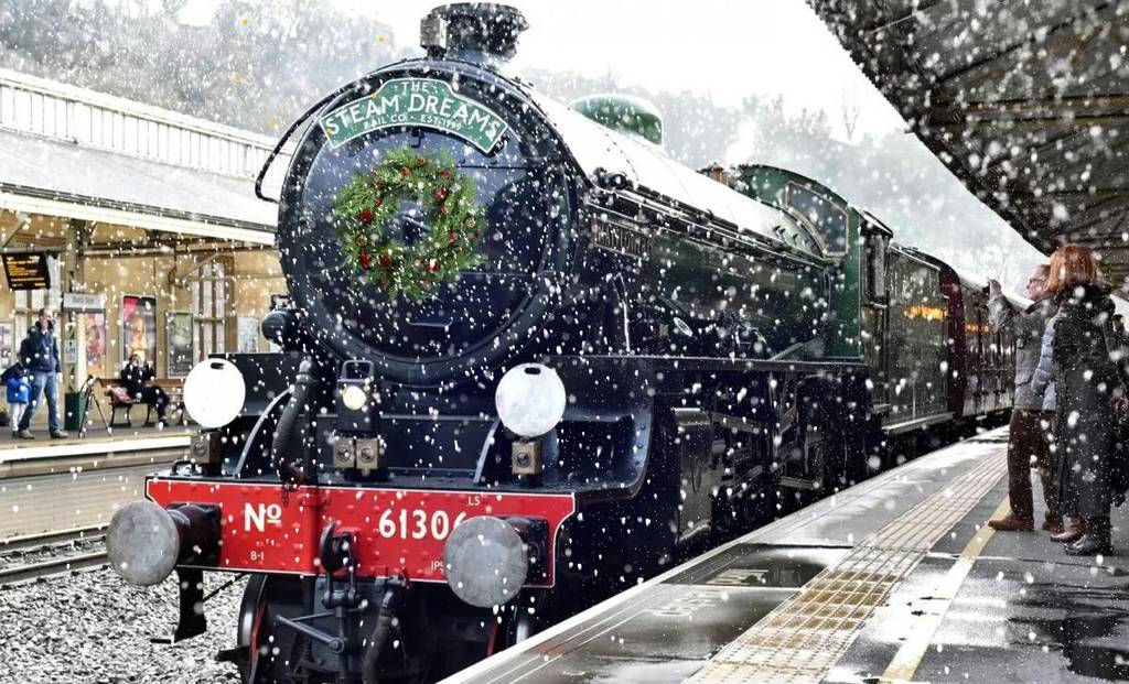 A vintage train pulled into a platform on a snowy day