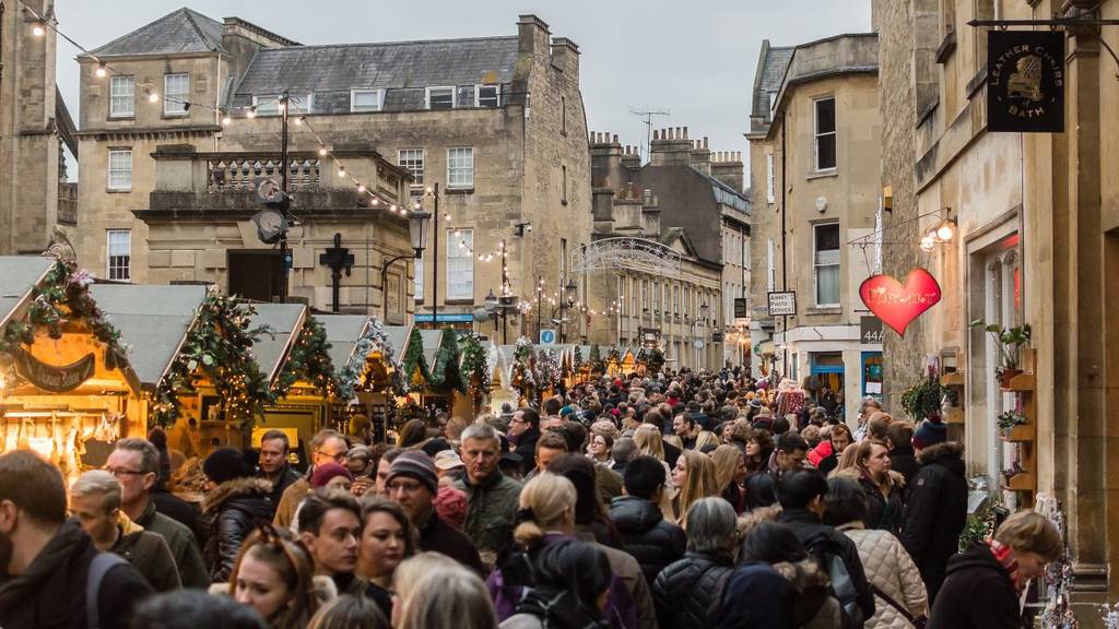 crowd walking down cobbled streets in bath for christmas market