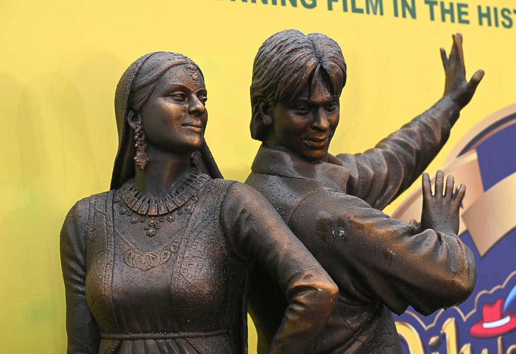 a bronze sculpture depicting the two stars of bollywood film ddlj. They are shown mid-dance, recreating a scene from the film
