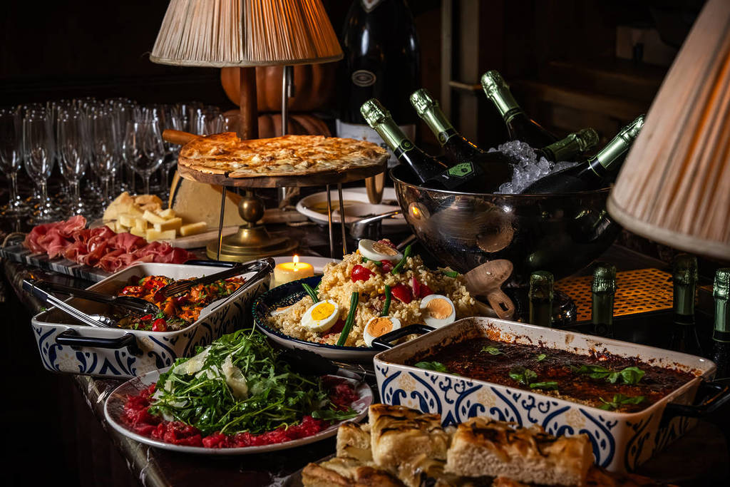 an indulgent buffet of italian food ranging from salads to filled flatbreads, aubergine parmigiana, beef, and more