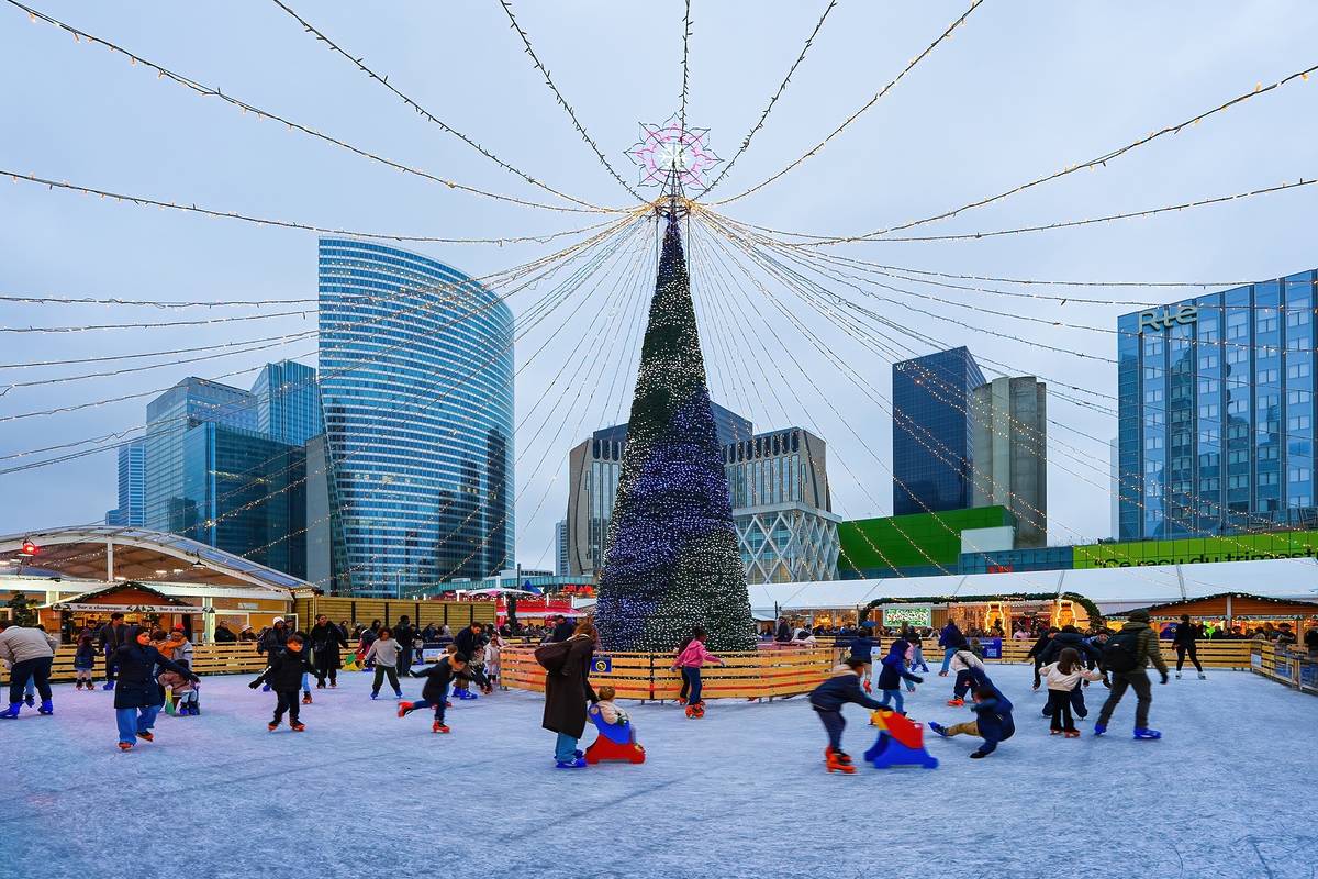 people skating around an ice rink, circling a tree, at La Defense Christmas Market