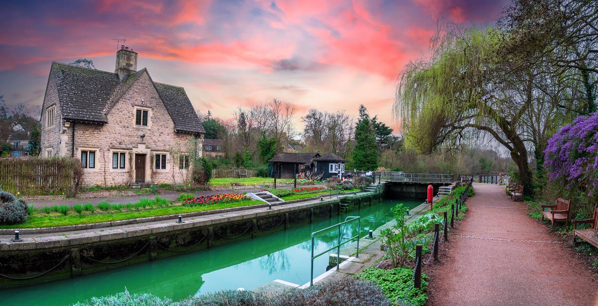 A view of Iffley Lock on the River Thames path at sunset with flowers blooming