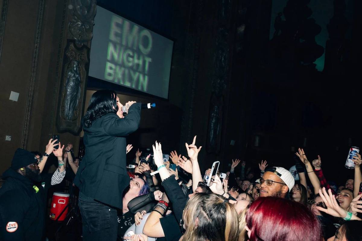 A DJ hyping up the audience at an emo dance rave party