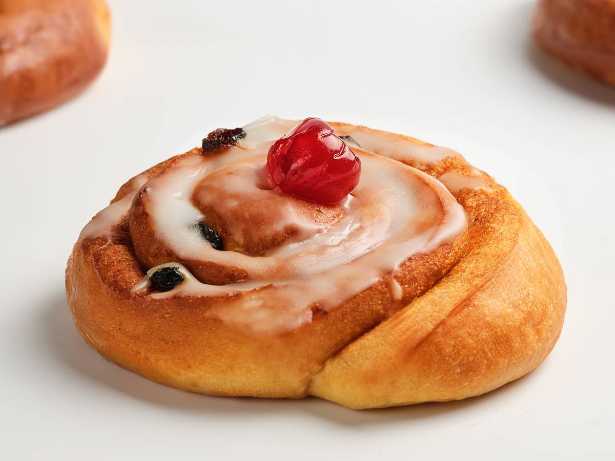 an iced bun with a glace cherry