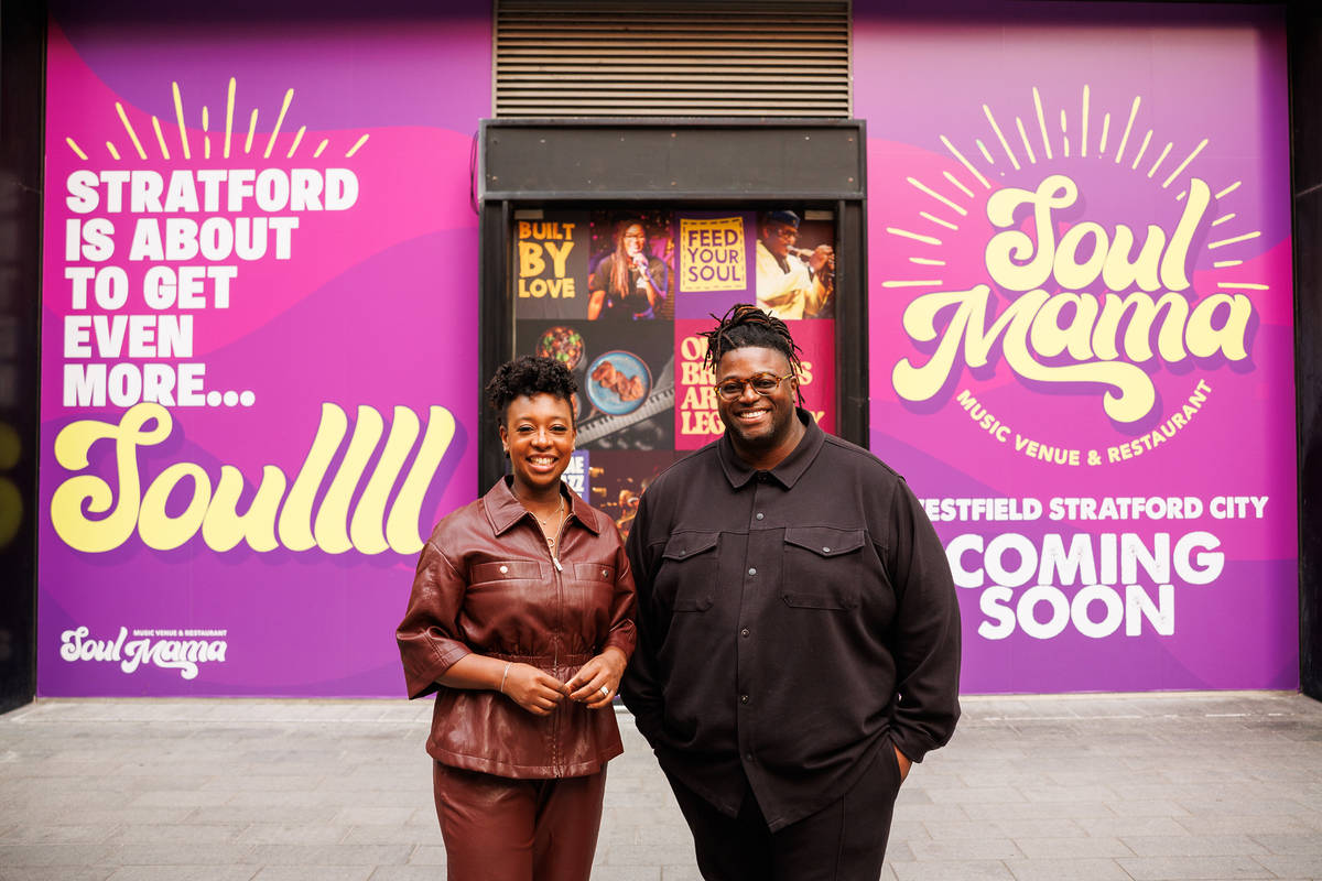 two people stood in front of the windows and entrance for the new restaurant soul mama westfield