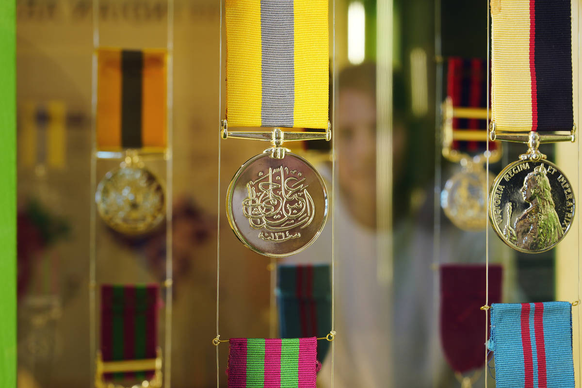 A close up of a medal with an iIdian script etched onto it