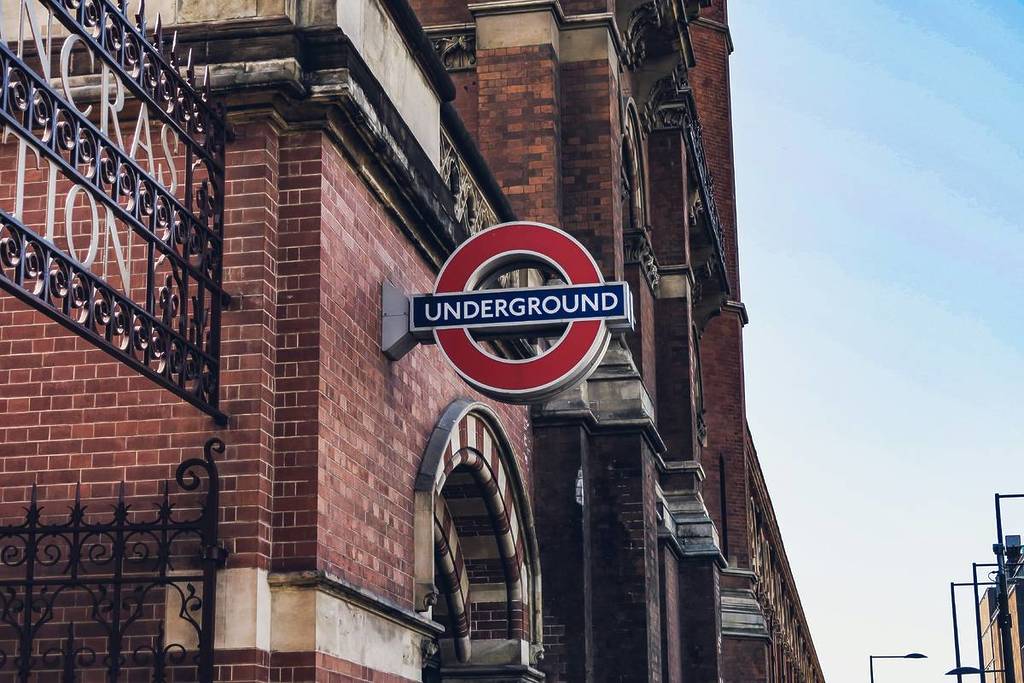 A London Underground sign hangs on the side of a brick building