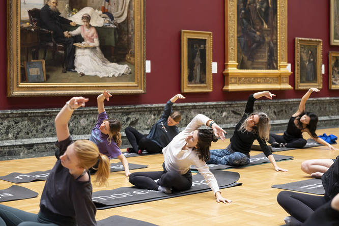 People doing yoga next to the art of Tate Britain