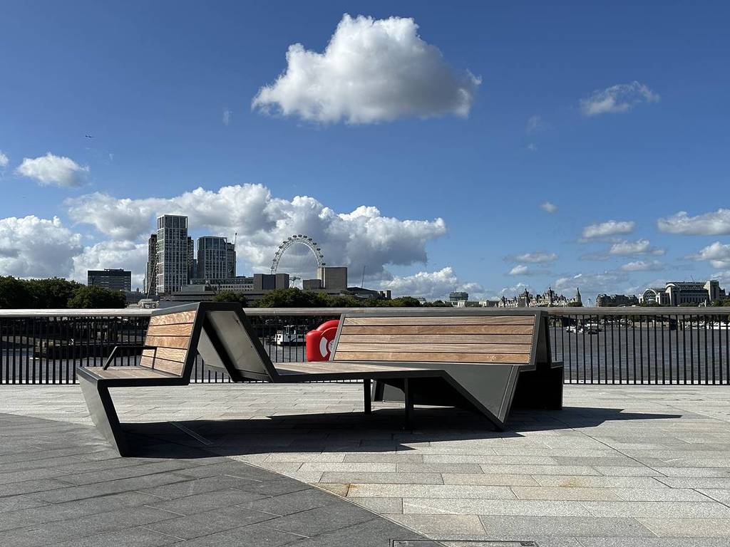a duo of benches on the Bazalgette Embankment with a riverside view of london behind