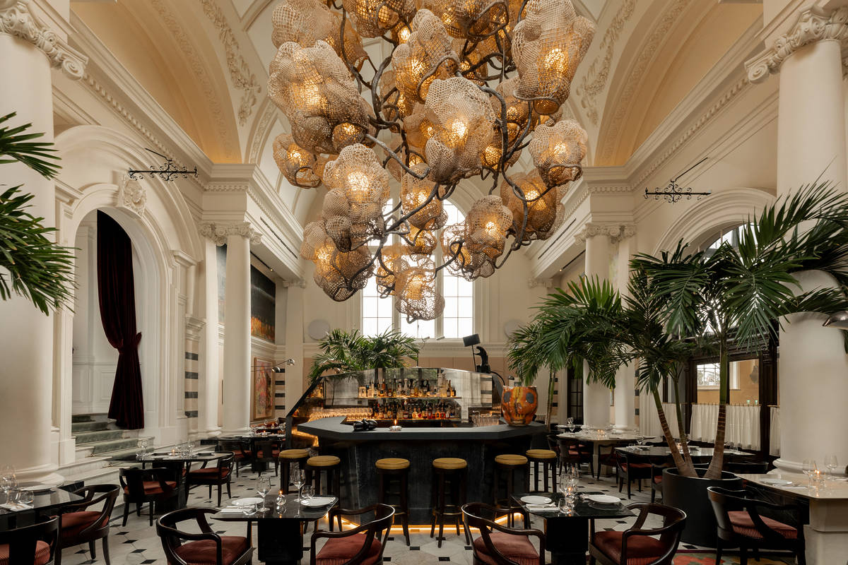 a dining area with an enormous elaborate 'cocoon chandelier' suspended overhead