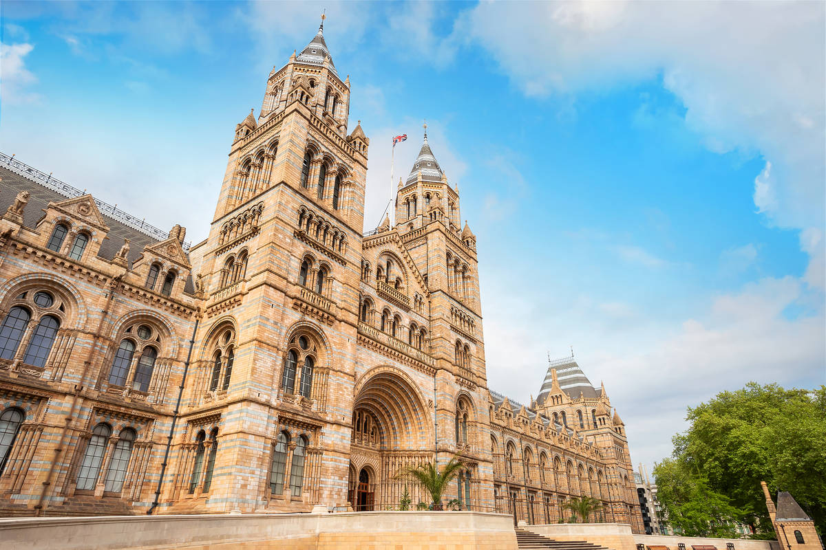 the exterior of the natural history museum on a sunny blue sky day