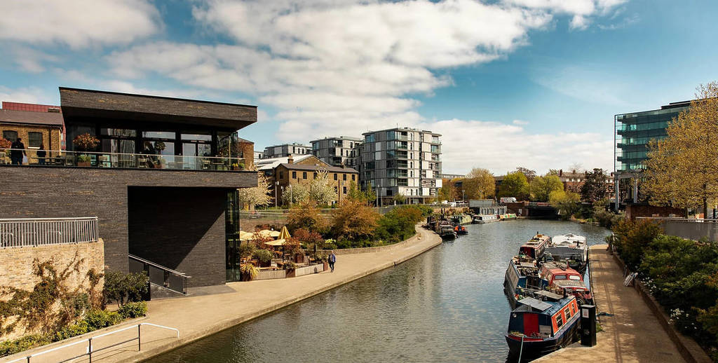 a gorgeous modern looking pub by the canal, with houseboats visible on the water
