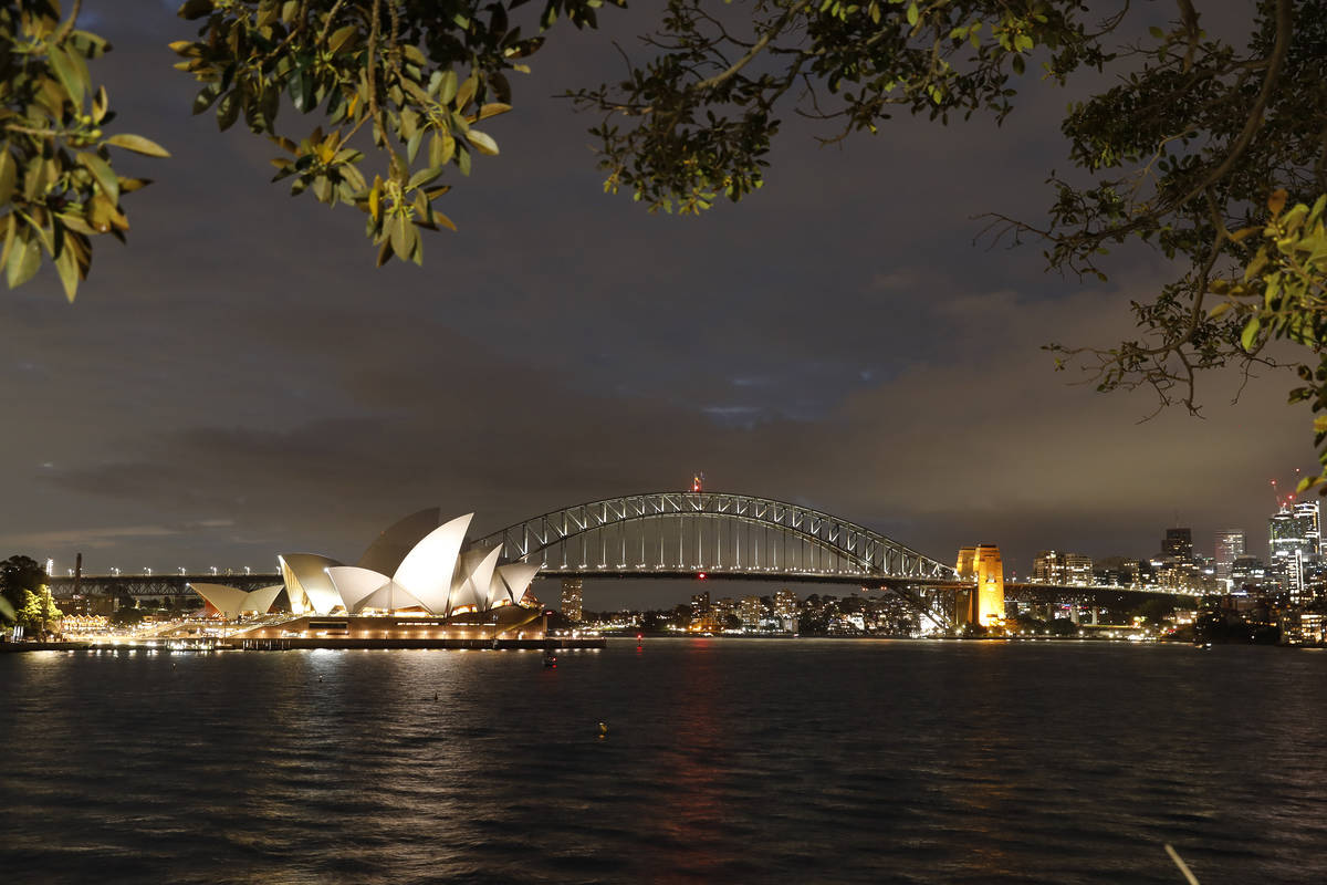 the sydney opera house and sydney harbour bridge at night