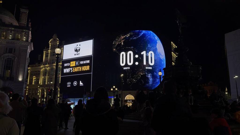 an earth hour countdown clock on a billboard in piccadilly circus