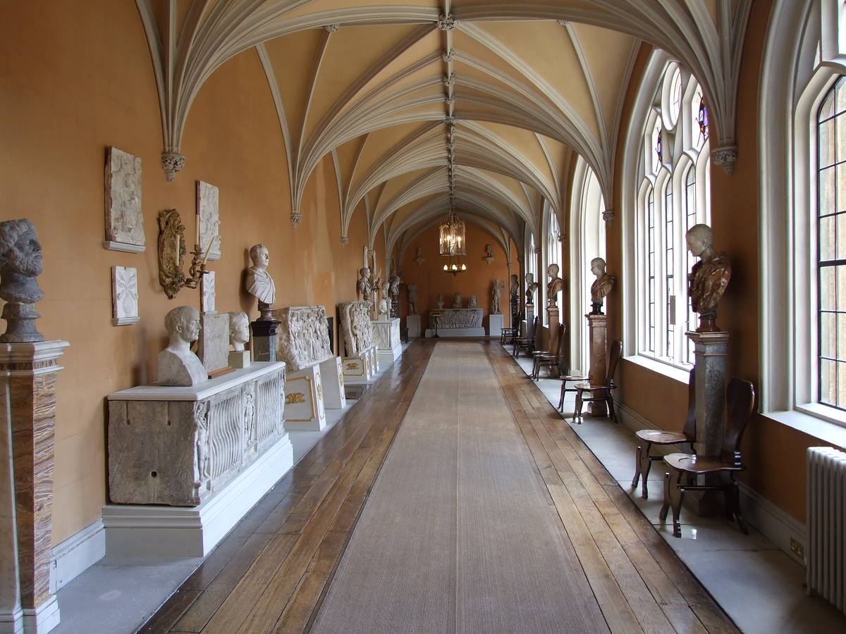 Cloisters inside a Gothic corridor of Wilton House featuring statue busts and arched ceilings