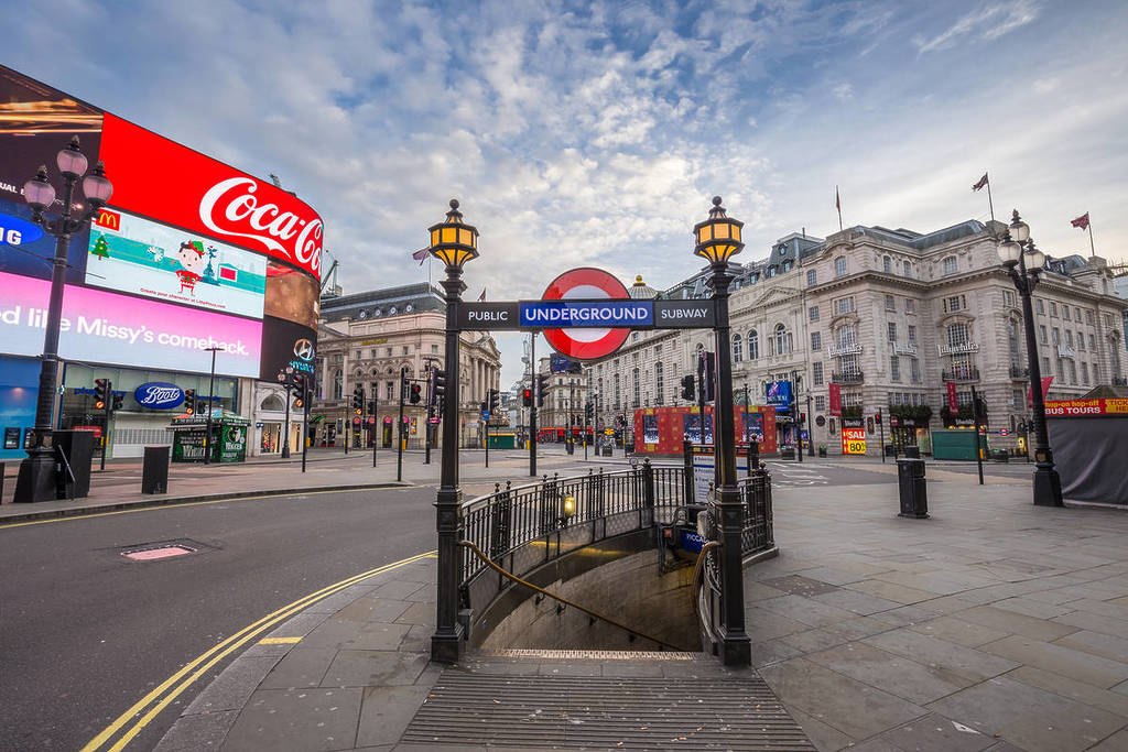 L'ingresso di una stazione della metropolitana con i cartelloni pubblicitari di Piccadilly Circus sullo sfondo