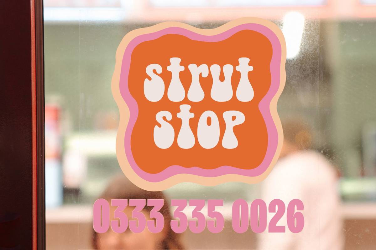 A "strut stop"sign o the window of a shop with the number of the hotline on the bottom