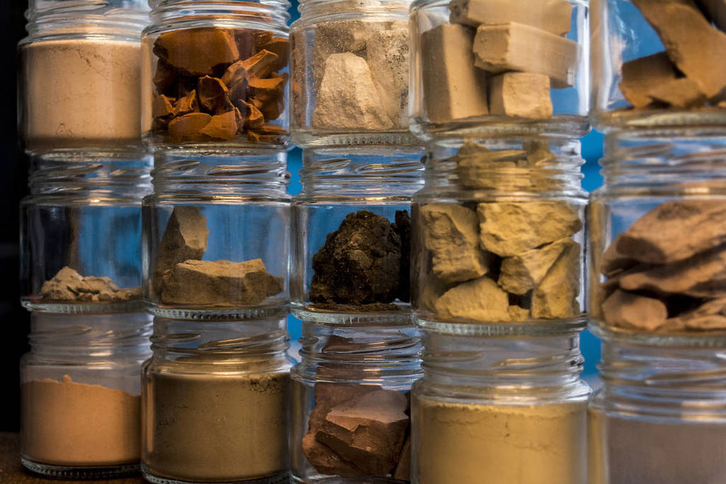 a selection of earth and rock samples in glass specimen jars