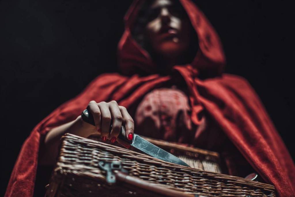 Little Red Riding Hood holding a knife in her basket 