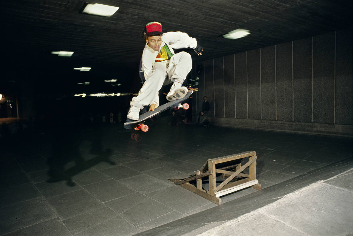 a skateboarder in the air, pulling a trick, having launched off a nearby kicker ramp