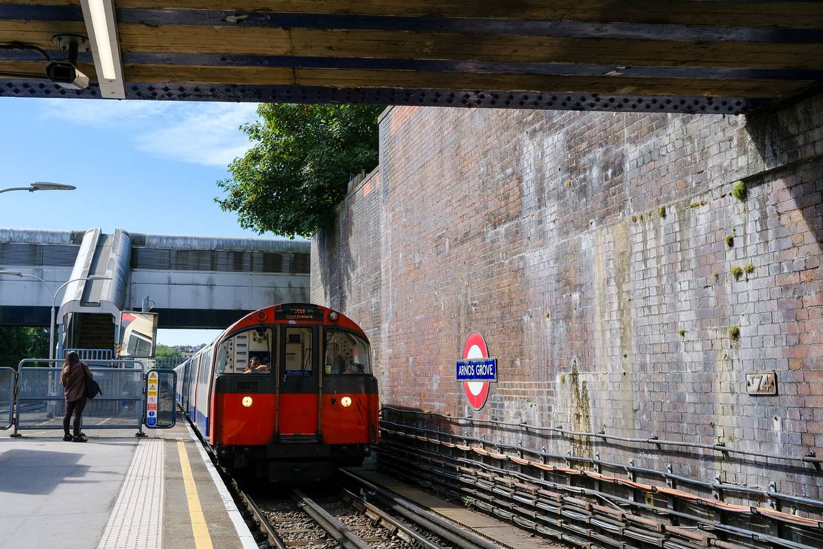 A tube pulling into the platform at Arnos Grove station