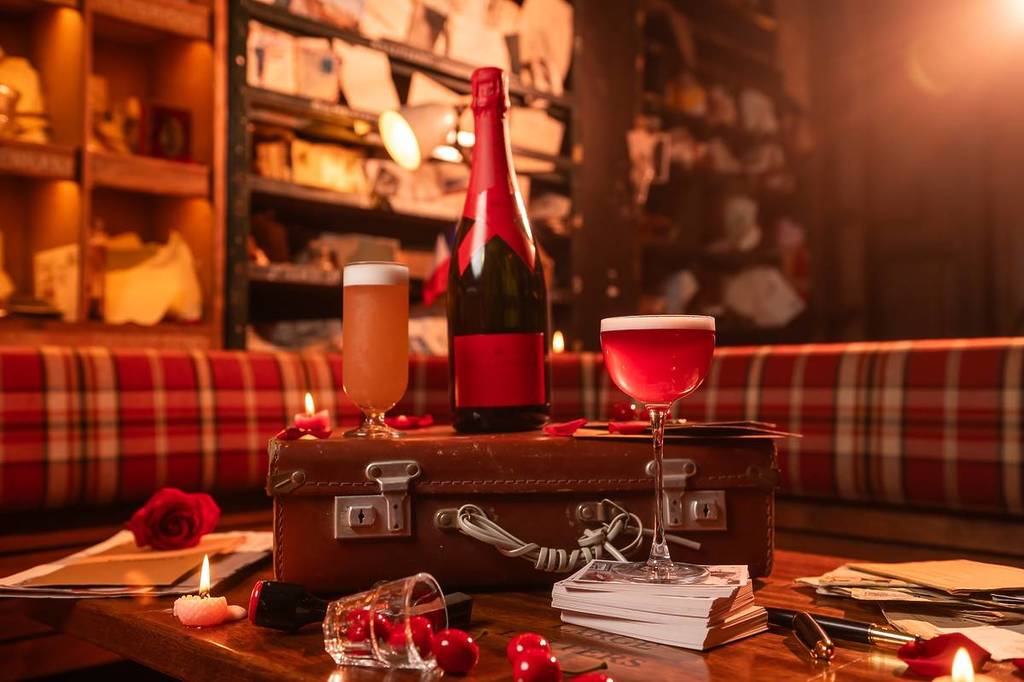 Un champán Moët con una etiqueta roja en una maleta en Cahoots Postal Office