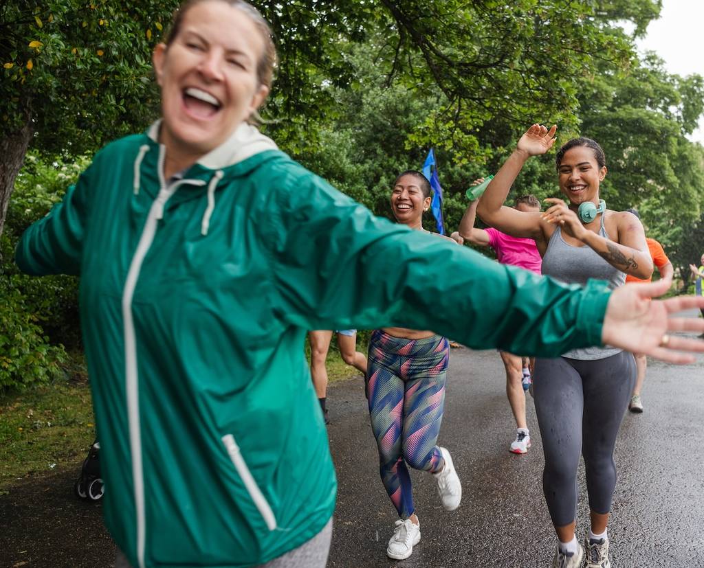 a group of women in 90s windbreakers and patterned leggings running together