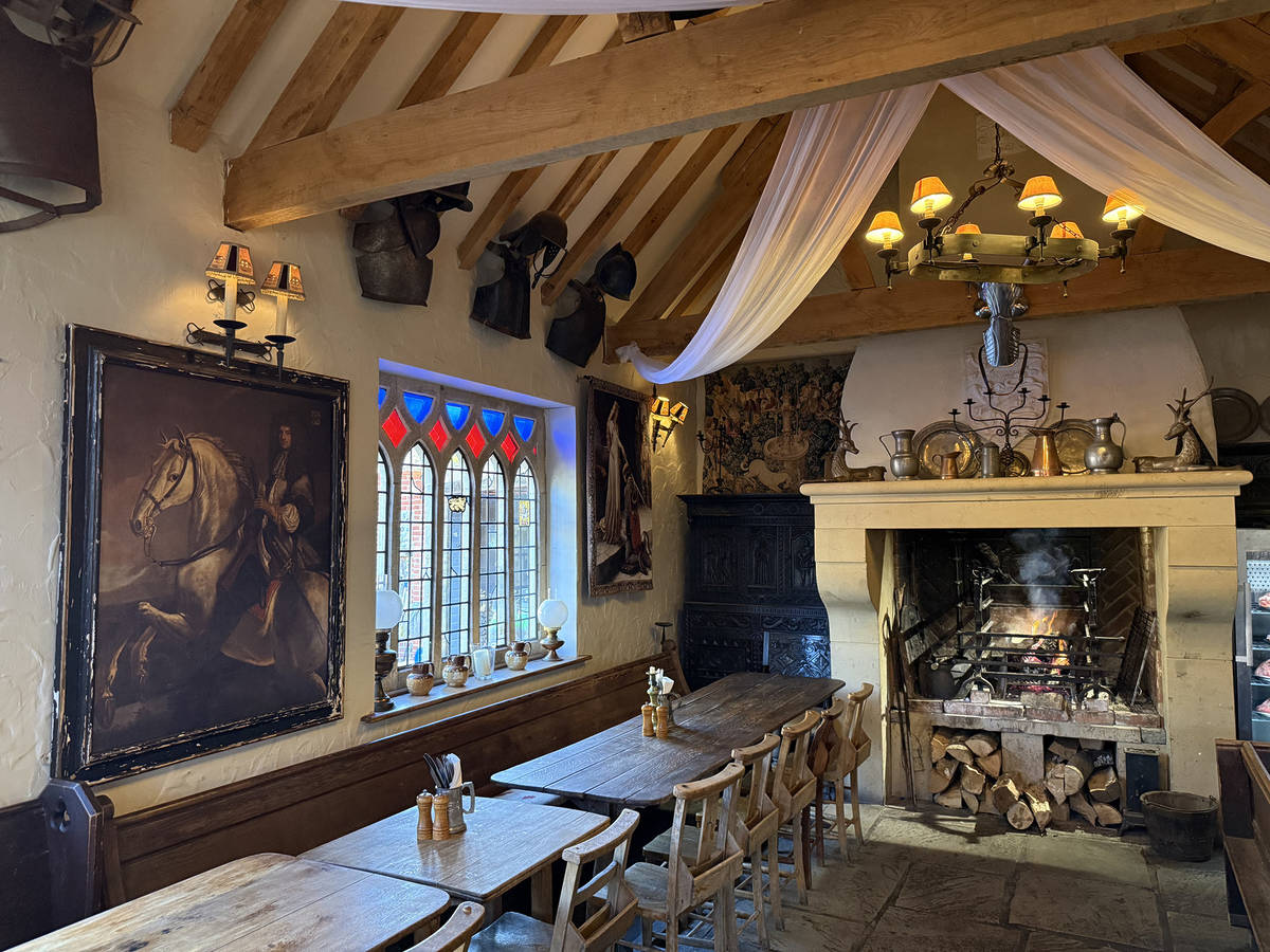 a handful of tables next to a roaring fire in a pub