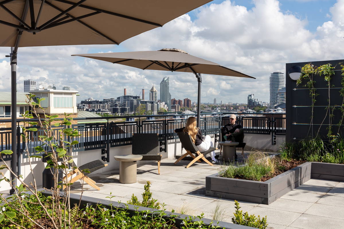Peopl sat relaxing on the roof terrace looking over London's skyline