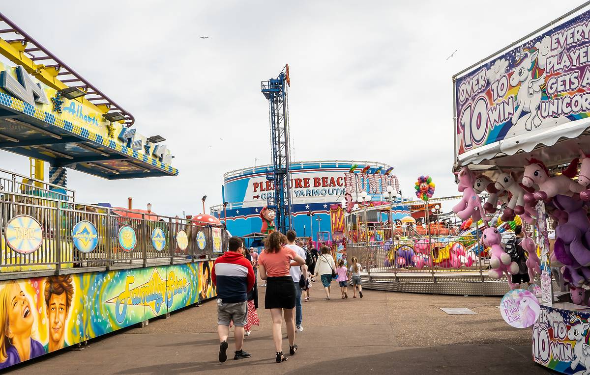 Great Yarmouth, Norfolk, UK – June 01 2019. A group of tourists heading towards the white-knuckle rides at Great Yarmouth Pleasure Beach theme park