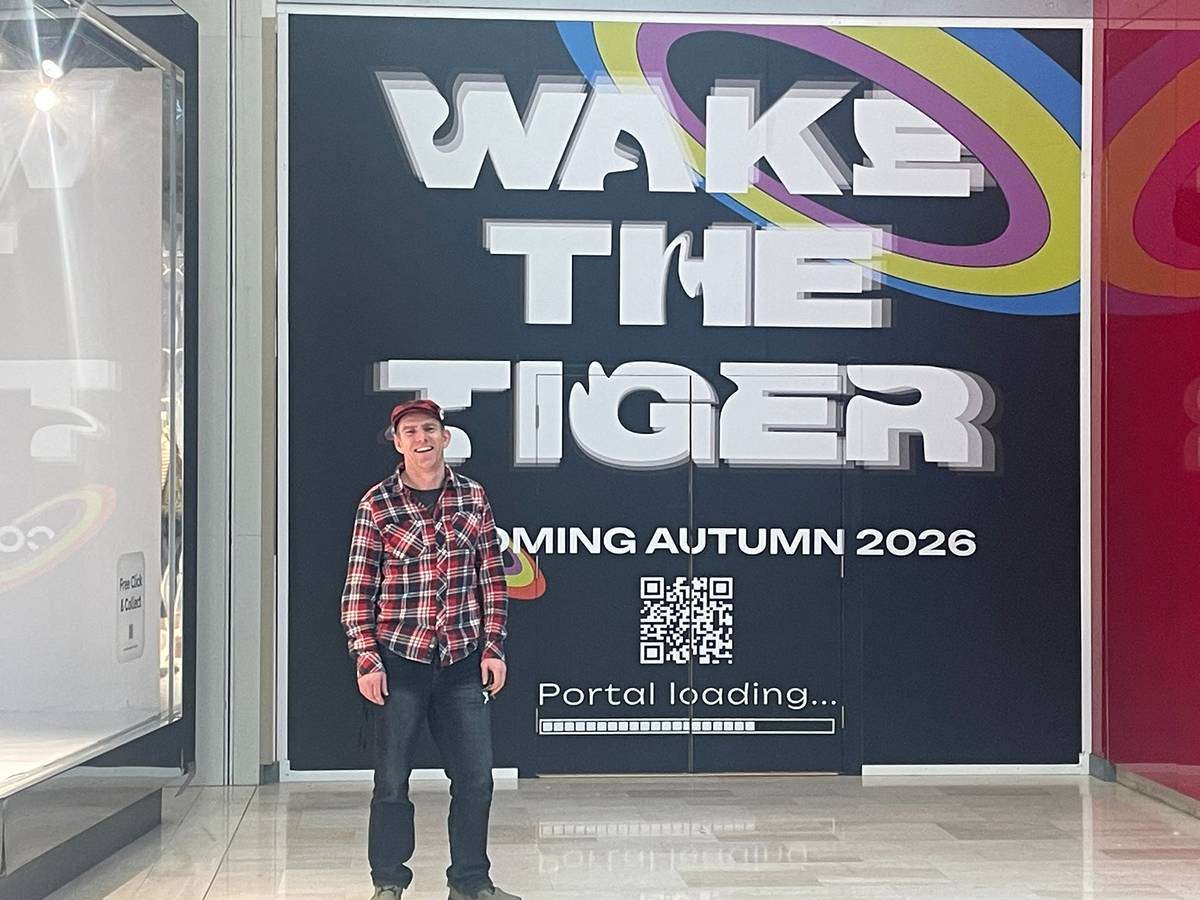 a man standing in front of doors emblazoned with WAKE THE TIGER